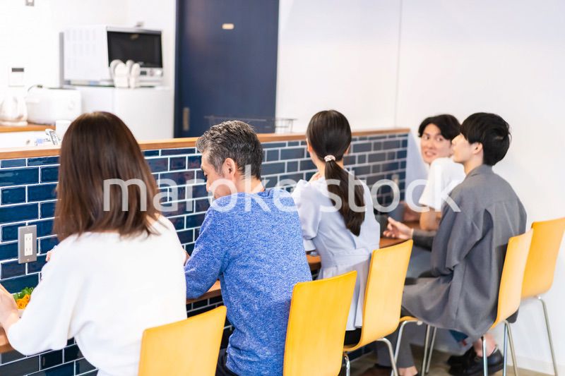レストランのカウンター席でご飯を食べる人々