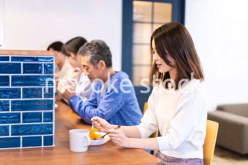 レストランのカウンター席でご飯を食べる人々