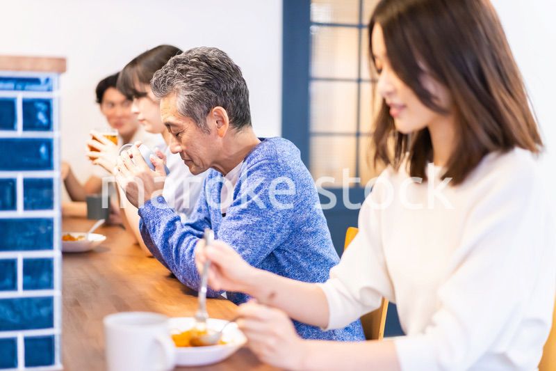 レストランのカウンター席でご飯を食べる人々