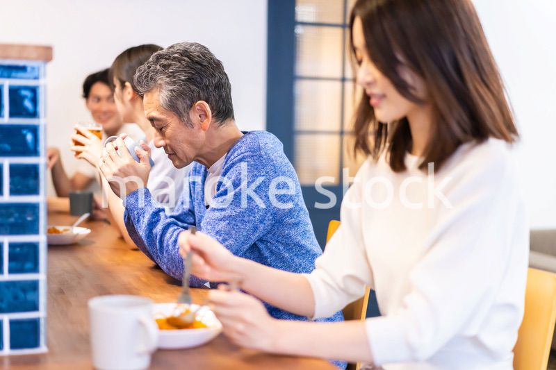 レストランのカウンター席でご飯を食べる人々