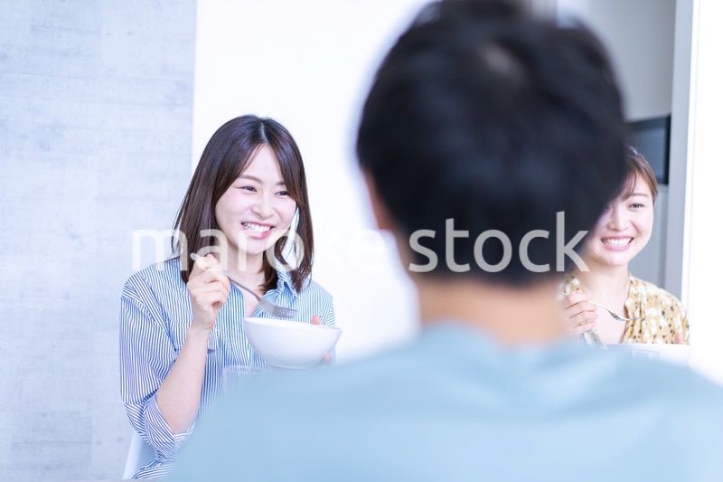 みんなで食事をする若い男女