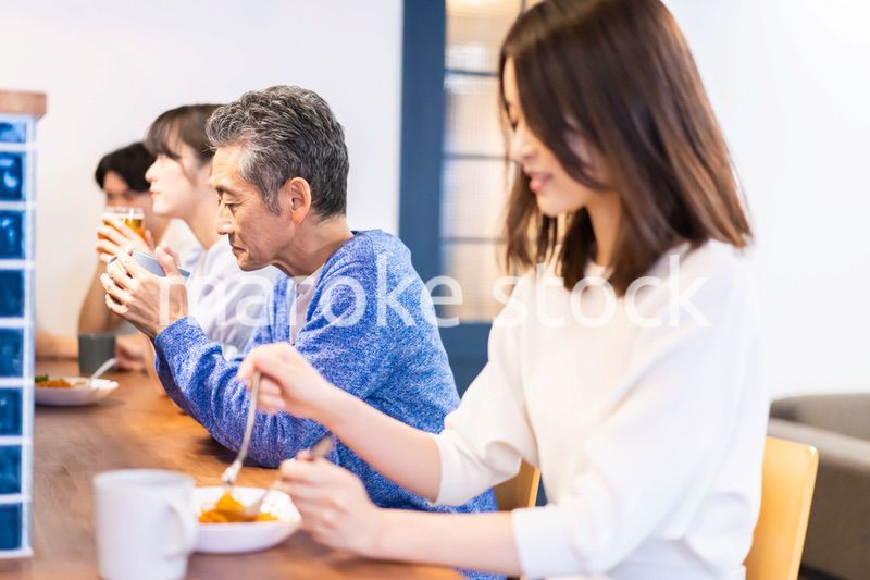 レストランのカウンター席でご飯を食べる人々