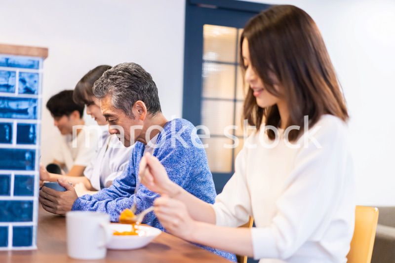 レストランのカウンター席でご飯を食べる人々