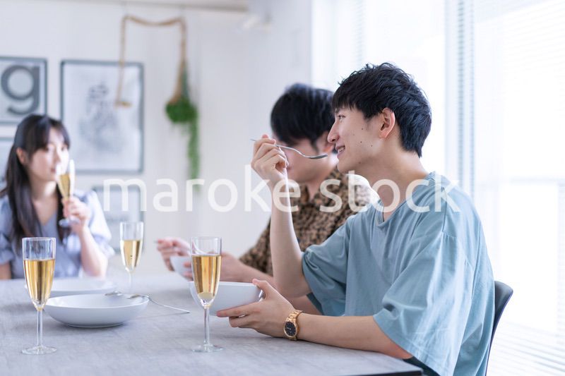 みんなで食事をする若い男女