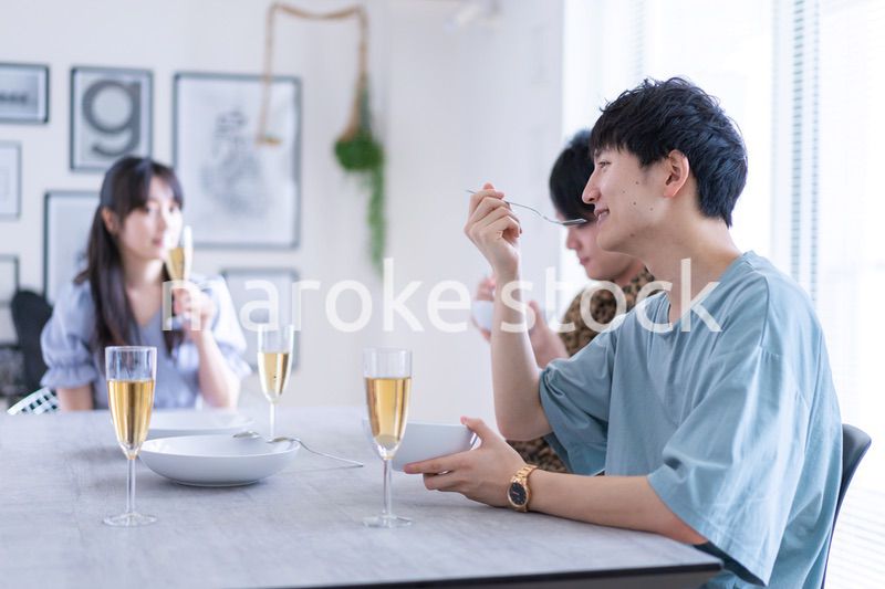 みんなで食事をする若い男女
