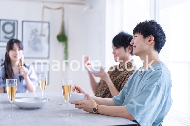 みんなで食事をする若い男女