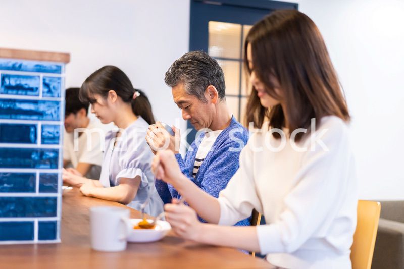 レストランのカウンター席でご飯を食べる人々