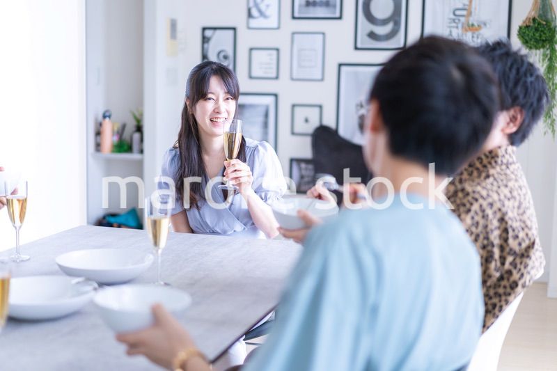 みんなで食事をする若い男女