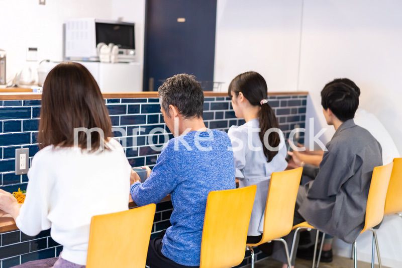 レストランのカウンター席でご飯を食べる人々