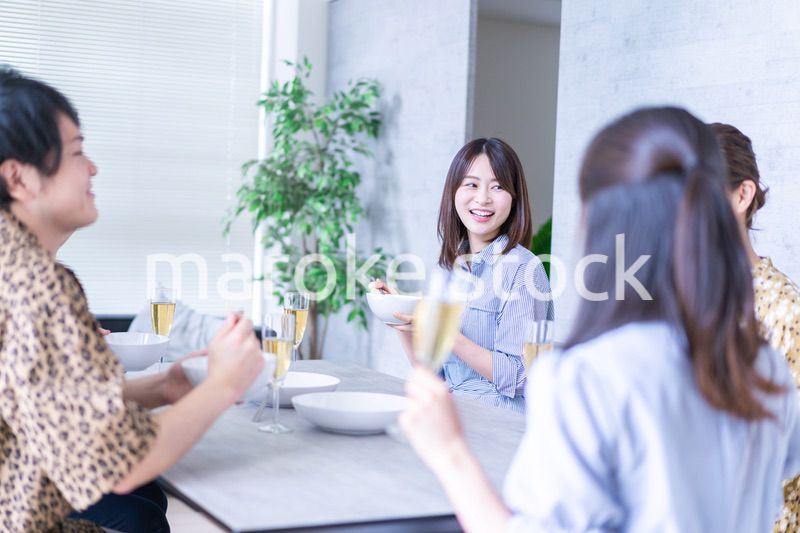 みんなで食事をする若い男女