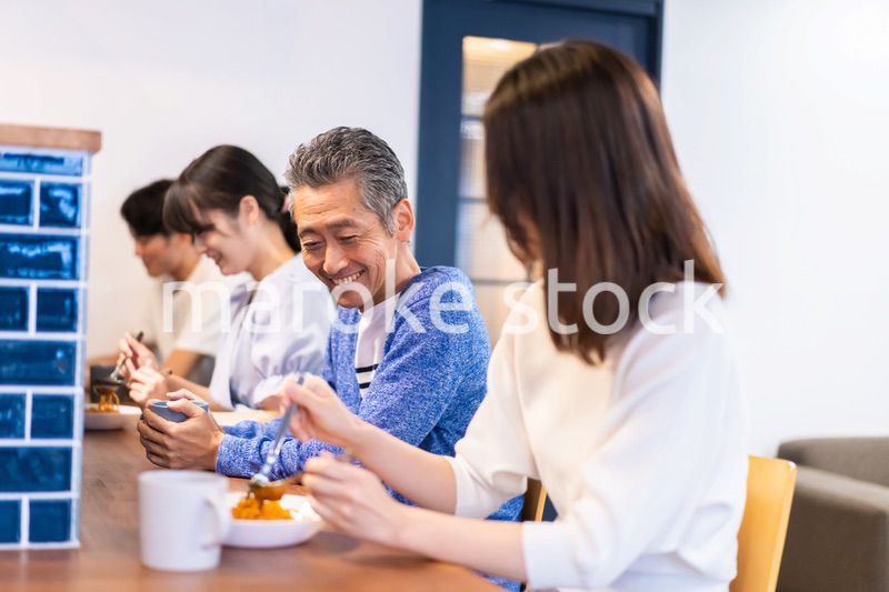レストランのカウンター席でご飯を食べる人々