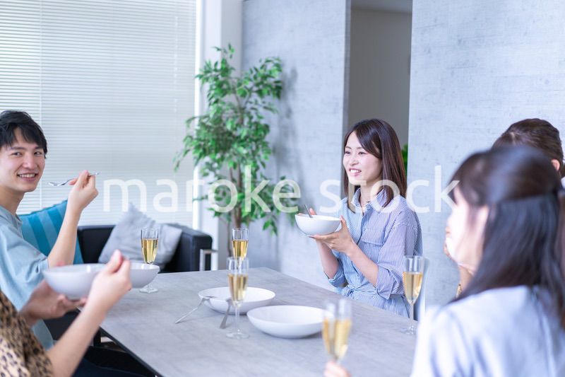 みんなで食事をする若い男女