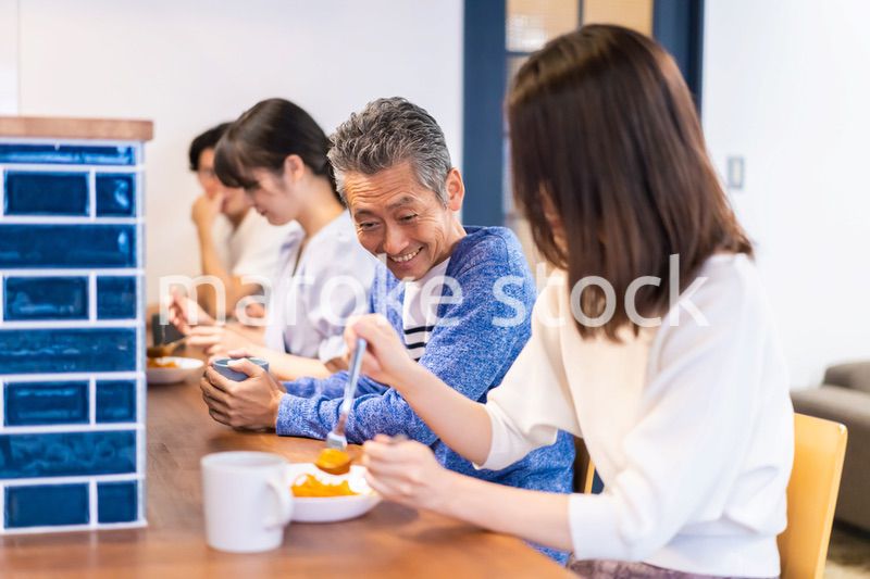 レストランのカウンター席でご飯を食べる人々
