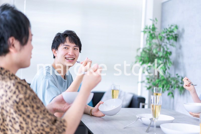 みんなで食事をする若い男女