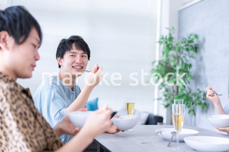 みんなで食事をする若い男女