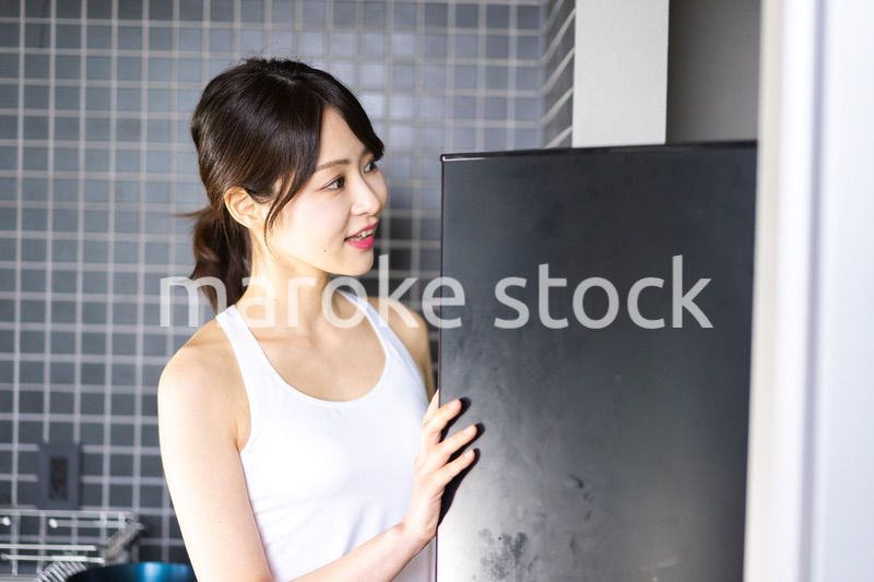 キッチンで料理をする若い女性