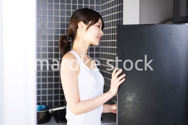 キッチンで料理をする若い女性