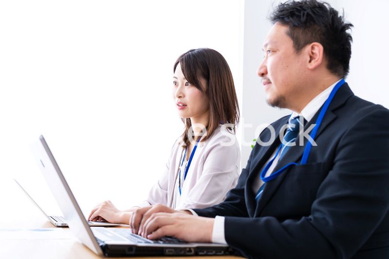 オフィスでデスクワークをする上司と部下