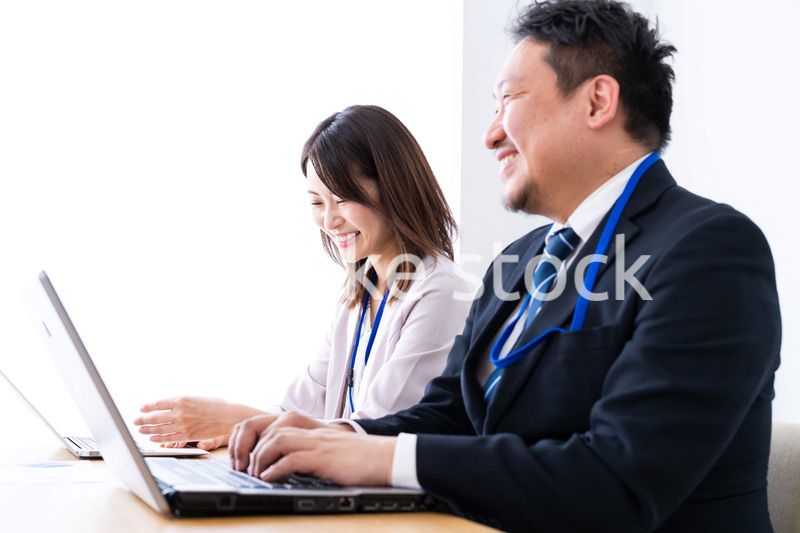 オフィスでデスクワークをする上司と部下