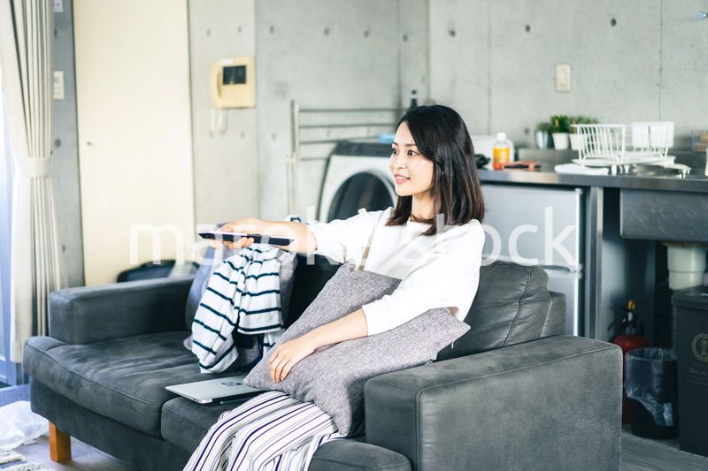 家でテレビを視聴する若い女性