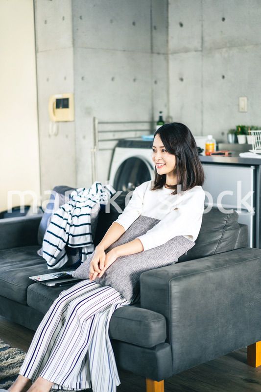 家でテレビを視聴する若い女性