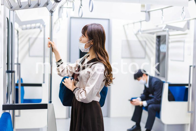 鼻だしマスクをして電車にのる女子高生