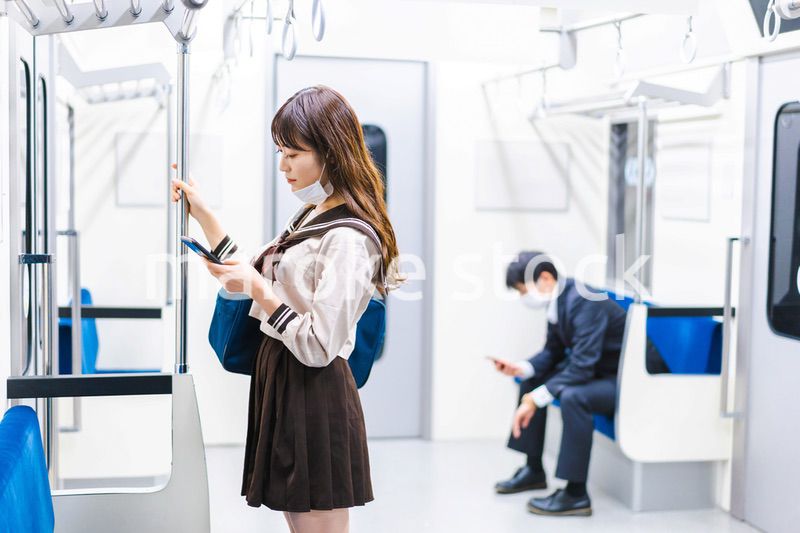 鼻だしマスクをして電車にのる女子高生