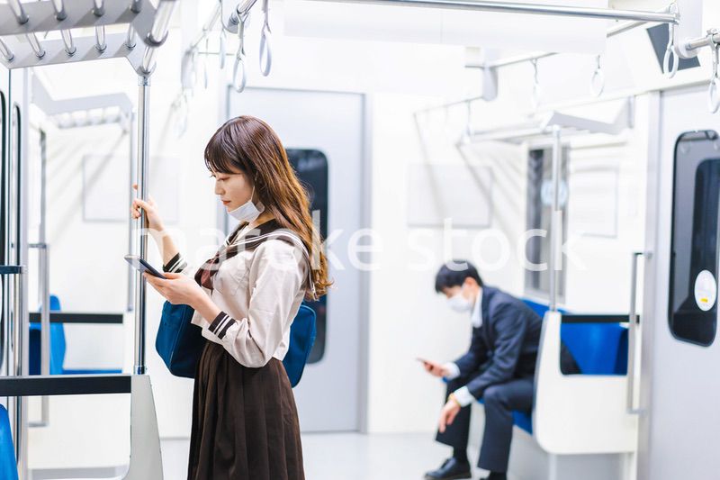 鼻だしマスクをして電車にのる女子高生