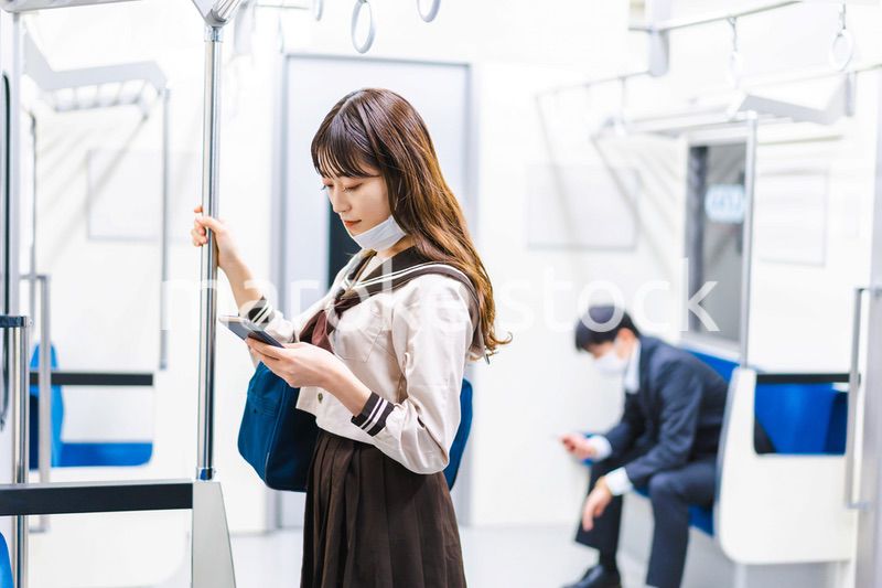 鼻だしマスクをして電車にのる女子高生