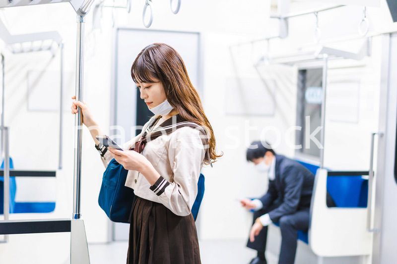 鼻だしマスクをして電車にのる女子高生