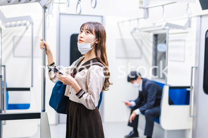 鼻だしマスクをして電車にのる女子高生