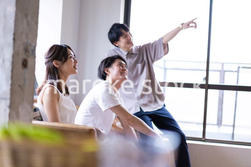 家でスポーツの試合を観戦する若い男女