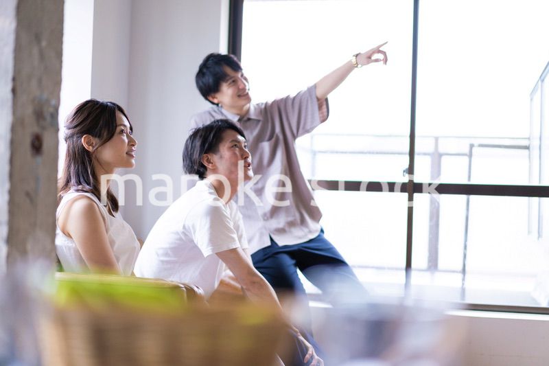 家でスポーツの試合を観戦する若い男女