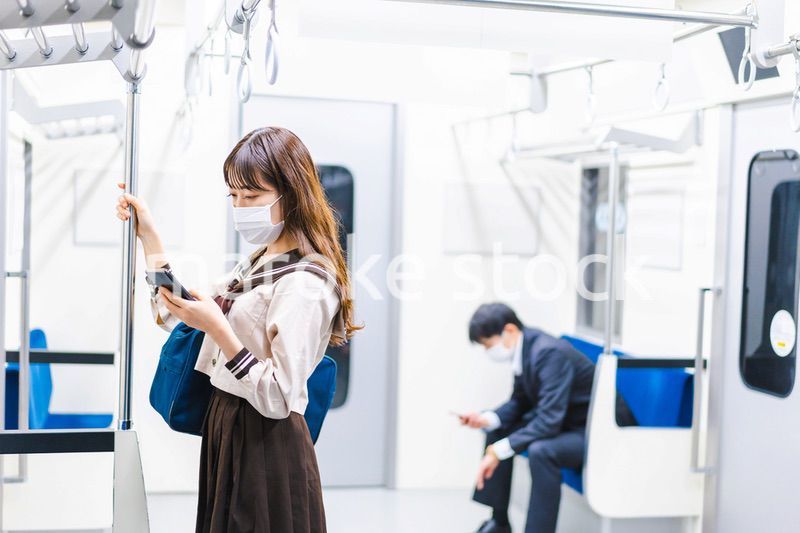 鼻だしマスクをして電車にのる女子高生