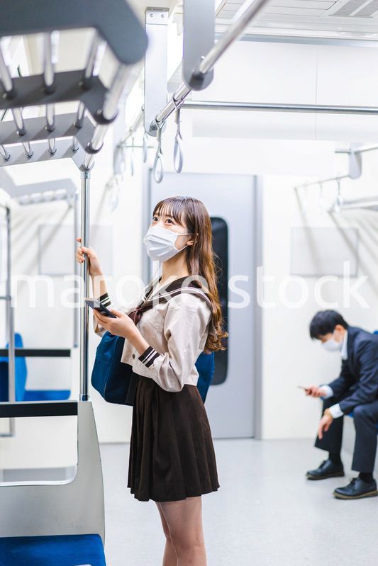 鼻だしマスクをして電車にのる女子高生