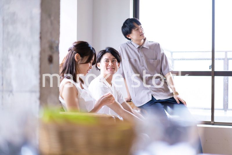 家でスポーツの試合を観戦する若い男女