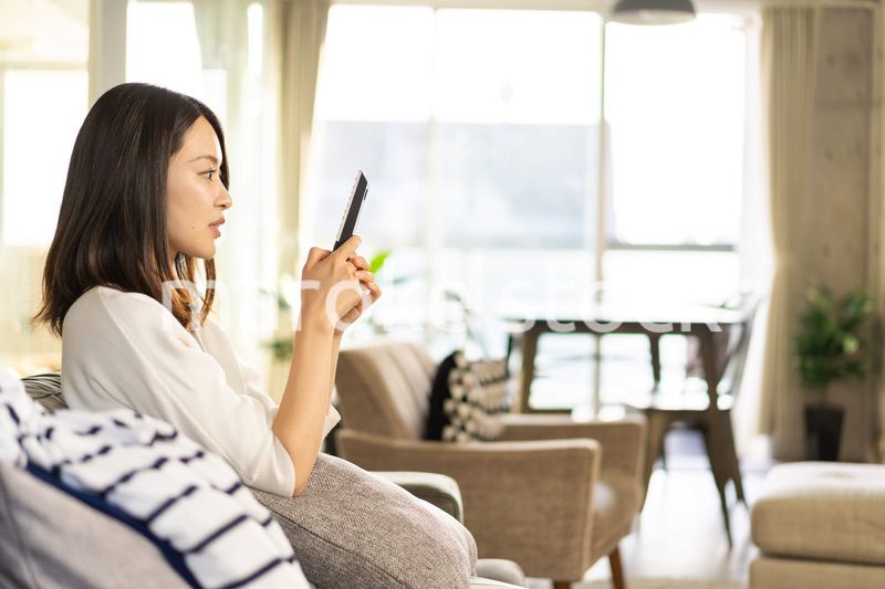 家でテレビを視聴する若い女性