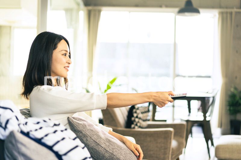 家でテレビを視聴する若い女性