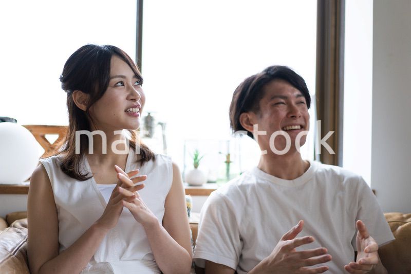 おうちでスポーツ観戦をするカップル