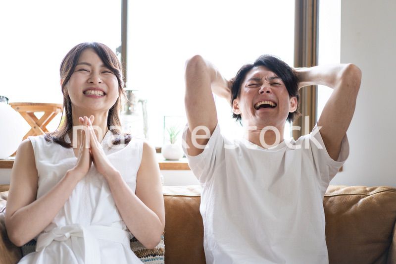 おうちでスポーツ観戦をするカップル