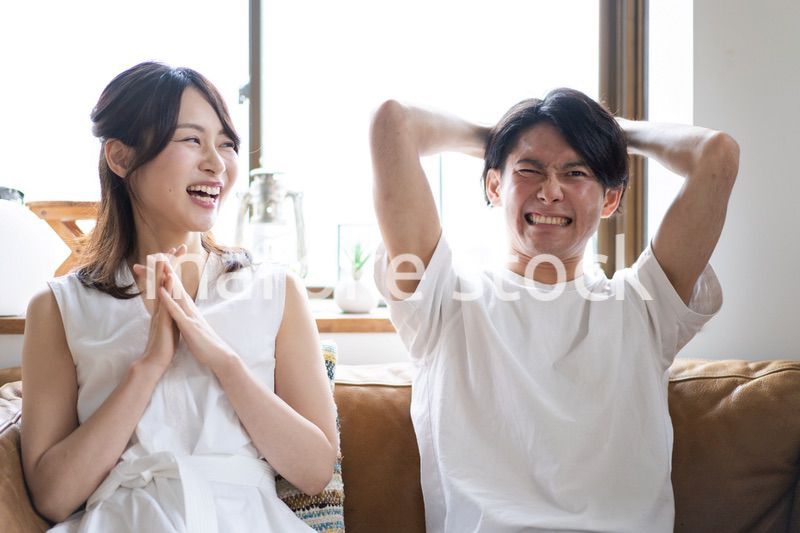 おうちでスポーツ観戦をするカップル