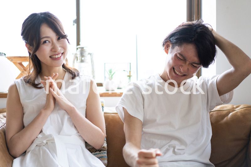 おうちでスポーツ観戦をするカップル