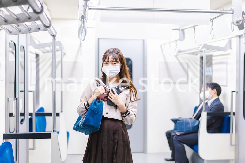 マスクをして電車通学をする女子高生
