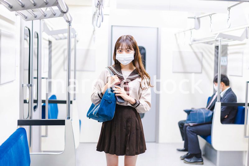 マスクをして電車通学をする女子高生