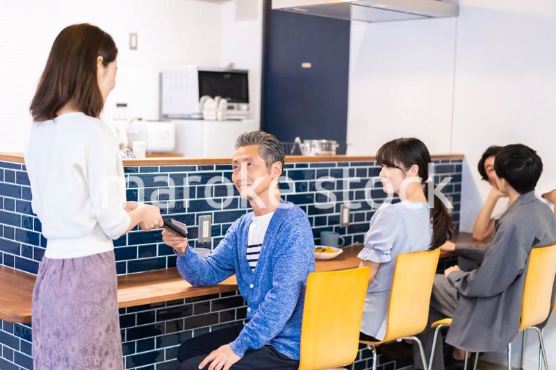 飲食店で電子マネー決済をする男性