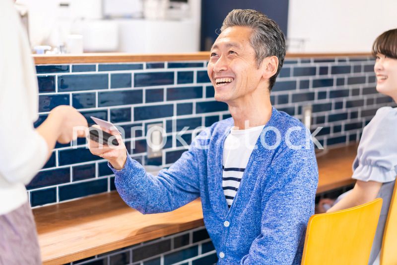 飲食店で電子マネー決済をする男性