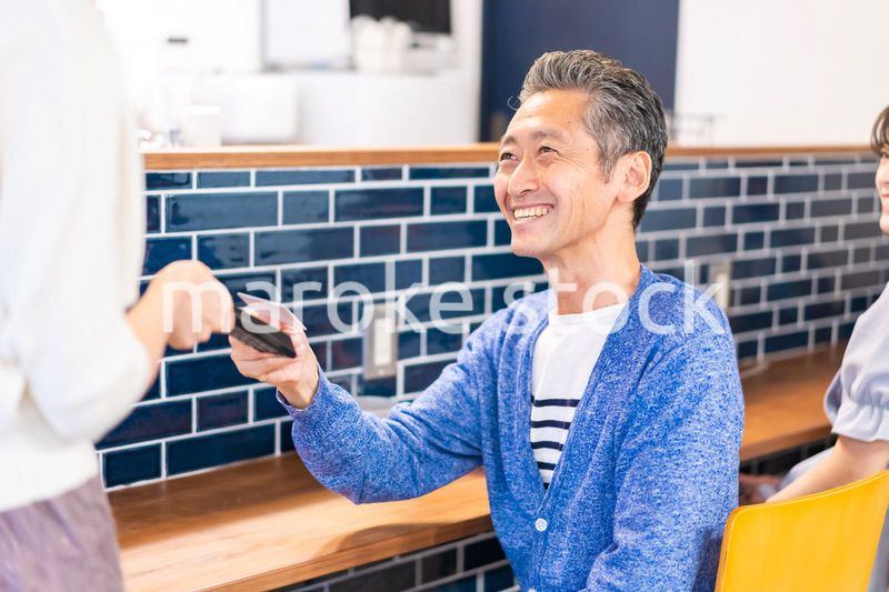 飲食店で電子マネー決済をする男性