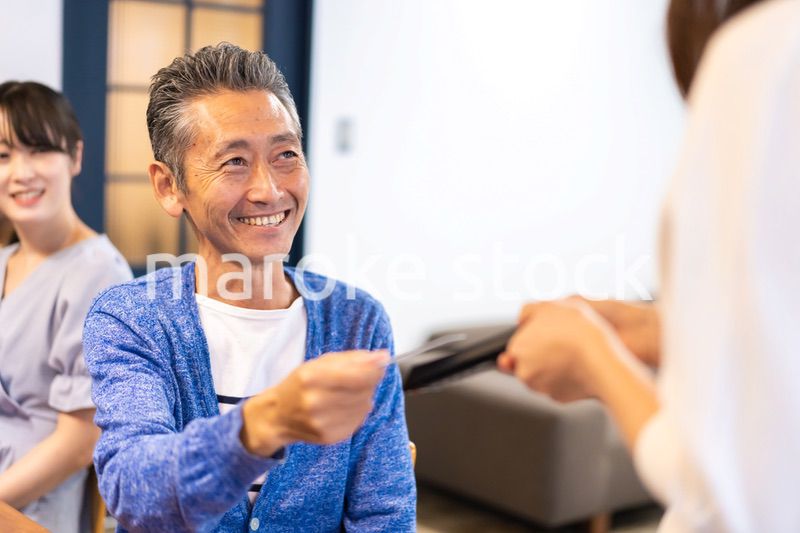 飲食店で電子マネー決済をする男性