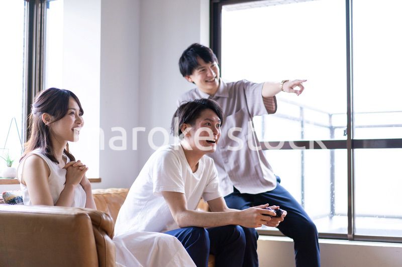 家でテレビゲームをする若い男女