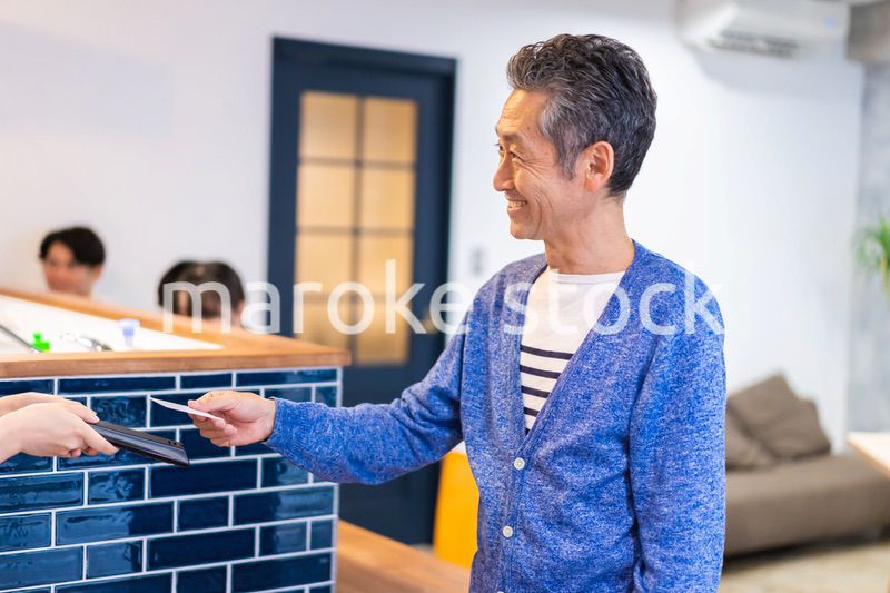 飲食店で電子マネー決済をする男性